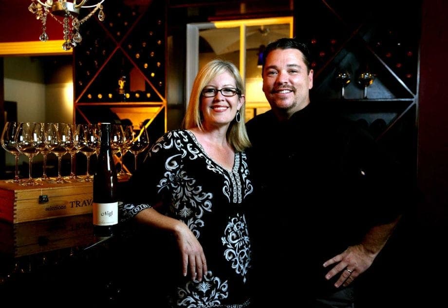 Ron and Claire Brandani at the wine bar with wine glasses and bottles